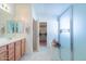 Bathroom featuring a double sink vanity, walk-in closet access, and shower at 41162 W Hayden Dr, Maricopa, AZ 85138