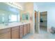 Bathroom with a double sink vanity, large mirror, and walk-in closet access at 41162 W Hayden Dr, Maricopa, AZ 85138