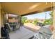 Covered patio with a grill, dining table, landscaping, and a hot tub at 41162 W Hayden Dr, Maricopa, AZ 85138