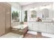 Bathroom featuring a double sink vanity, soaking tub, and glass-enclosed shower with granite-look finishes at 4215 W Hackamore Dr, Phoenix, AZ 85083