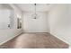 This is an empty dining room with tile flooring and a modern chandelier, ready for entertaining at 4215 W Hackamore Dr, Phoenix, AZ 85083