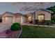 Home's inviting exterior, with three-car garage, manicured lawn, and elegant entryway lighting at 4215 W Hackamore Dr, Phoenix, AZ 85083