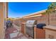 An outdoor kitchen is featured with a stainless steel grill, counter space and tiled accents at 4215 W Hackamore Dr, Phoenix, AZ 85083