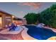 The backyard features a pool with rock waterfall, covered patio, and lush landscaping at 4215 W Hackamore Dr, Phoenix, AZ 85083