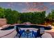 Relaxing poolside seating with chairs, table, and a view of the rock waterfall feature at 4215 W Hackamore Dr, Phoenix, AZ 85083