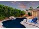 Backyard pool with rock waterfall feature, mature trees, and lounge area at 4215 W Hackamore Dr, Phoenix, AZ 85083