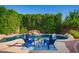 Backyard oasis with a rock waterfall, pool and lounge area with two blue Adirondack chairs at 4215 W Hackamore Dr, Phoenix, AZ 85083