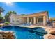 Inviting pool with rock features, lush landscaping, patio and covered patio with outdoor kitchen at 4215 W Hackamore Dr, Phoenix, AZ 85083