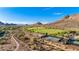Scenic aerial view of community park featuring tennis courts and open green space surrounded by mountains at 4215 W Hackamore Dr, Phoenix, AZ 85083