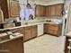 Well-lit kitchen with tile flooring, plenty of counterspace, and ample wood cabinet storage at 4301 E Amberwood Dr, Phoenix, AZ 85048