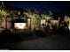 Backyard with stone fountain, rock landscaping, palm trees, paver patio and landscape lighting at night at 4426 E Leroy St, Gilbert, AZ 85295