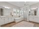 Bathroom with dual sinks, white cabinets, tub and walk-in shower at 4426 E Leroy St, Gilbert, AZ 85295