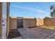 Brick-paved backyard space featuring metal gate, a small patch of grass, and lush foliage at 4714 E Broadway Rd, Phoenix, AZ 85040