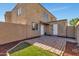 Backyard area with brick-paved section, landscaped area, and neutral stucco wall at 4714 E Broadway Rd, Phoenix, AZ 85040