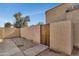 Fenced backyard area with gravel landscaping and a wooden gate for access at 4714 E Broadway Rd, Phoenix, AZ 85040