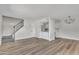 Spacious living room featuring wood floors and an open floor plan leading to the kitchen and staircase at 4714 E Broadway Rd, Phoenix, AZ 85040