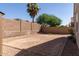 An empty backyard space enclosed by brick walls, awaiting landscaping and personalization for outdoor enjoyment at 6999 S Blue Hills Dr, Buckeye, AZ 85326