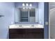 Bathroom featuring a dual sink vanity with dark wood cabinets, and a large mirror at 6999 S Blue Hills Dr, Buckeye, AZ 85326