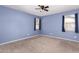 Empty bedroom with carpet, a ceiling fan, and windows providing natural light at 6999 S Blue Hills Dr, Buckeye, AZ 85326