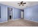 Spacious bedroom with neutral carpet, adjacent bathroom entrance, and natural light at 6999 S Blue Hills Dr, Buckeye, AZ 85326