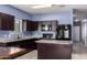 Stylish kitchen featuring dark wood cabinets, sleek countertops, modern appliances, and an island at 6999 S Blue Hills Dr, Buckeye, AZ 85326