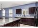 A spacious kitchen featuring granite countertops, a center island, and modern dark wood cabinetry at 6999 S Blue Hills Dr, Buckeye, AZ 85326