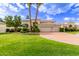 Elegant home exterior with lush landscaping, mature trees, and a three car garage at 7376 E Via Estrella Ave, Scottsdale, AZ 85258