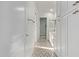 Hallway leading to bathroom with patterned tile, white cabinets, and golden hardware at 7376 E Via Estrella Ave, Scottsdale, AZ 85258