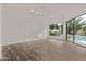 Bright living room with wood-look floors, modern lighting, and access to a pool and patio at 7376 E Via Estrella Ave, Scottsdale, AZ 85258