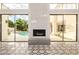 Bright living room with sliding doors and fireplace overlooking the pool area and lush greenery at 7376 E Via Estrella Ave, Scottsdale, AZ 85258