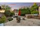 Private backyard offering a covered patio, outdoor kitchen area, mature trees, and a water feature at 8139 E Club Village Dr, Gold Canyon, AZ 85118