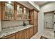 Elegant butler's pantry featuring glass-front cabinets, granite countertops, and ample storage space at 8139 E Club Village Dr, Gold Canyon, AZ 85118