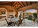 Expansive covered patio with a fireplace, seating area, and views of the nearby golf course at 8139 E Club Village Dr, Gold Canyon, AZ 85118