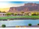Picturesque lakefront home with tile roof, mature landscaping, and views of mountain at 8139 E Club Village Dr, Gold Canyon, AZ 85118