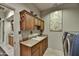 Functional laundry room featuring wood cabinets, tile floors, and a full-size washer and dryer set at 8139 E Club Village Dr, Gold Canyon, AZ 85118
