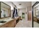 Lavish bathroom featuring a long vanity, dual sinks, sconces, framed mirrors, and a walk-in closet at 8139 E Club Village Dr, Gold Canyon, AZ 85118