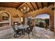 Charming outdoor living area with stone floors, fireplace, and view of the fire pit at 8139 E Club Village Dr, Gold Canyon, AZ 85118