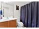 Bathroom featuring a single vanity, a framed mirror, and a toilet with a blue patterned shower curtain at 8429 W Vernon Ave, Phoenix, AZ 85037