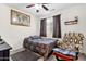 Bedroom features a bed with a decorative patterned quilt, an armchair, and a large world map on the wall at 8429 W Vernon Ave, Phoenix, AZ 85037