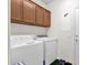 Functional laundry room featuring a washer, dryer, and overhead cabinets for storage at 8429 W Vernon Ave, Phoenix, AZ 85037