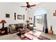 Bright living room featuring a ceiling fan, tile flooring, and a large arched window at 8429 W Vernon Ave, Phoenix, AZ 85037