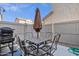 Outdoor patio features patio furniture for dining under an umbrella and a grill for barbecuing at 8429 W Vernon Ave, Phoenix, AZ 85037