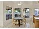 Bright dining area filled with light, featuring a ceiling fan and a wooden table with modern chairs at 9 E Los Arboles Cir, Tempe, AZ 85284