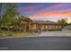 Beautiful single-story home with desert landscaping, tile roof, and a view of a colorful sunset at 9 E Los Arboles Cir, Tempe, AZ 85284