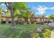 Charming single-Gathering home featuring lush landscaping, mature trees, and a well-manicured lawn at 9 E Los Arboles Cir, Tempe, AZ 85284