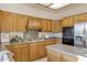 Traditional kitchen with wood cabinets, granite countertops, a center island, and modern appliances at 9 E Los Arboles Cir, Tempe, AZ 85284