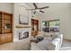 Cozy living room with a fireplace, built-in bookshelves, comfortable seating, and natural light at 9 E Los Arboles Cir, Tempe, AZ 85284