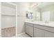 Bathroom featuring a dual sink vanity with light gray cabinets and an adjacent walk-in closet at 9822 W Caron Dr, Peoria, AZ 85345