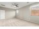 Spacious bedroom with a ceiling fan, natural light, and an attached door at 9822 W Caron Dr, Peoria, AZ 85345