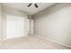 Bedroom with a ceiling fan, closet doors, and neutral colored walls and carpet at 9822 W Caron Dr, Peoria, AZ 85345